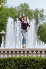 Girl ballerina in jeans, a plaid shirt and pointe shoes dancing in the city on the street © Tatiana