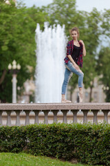 Girl ballerina in jeans, a plaid shirt and pointe shoes dancing in the city on the street © Tatiana