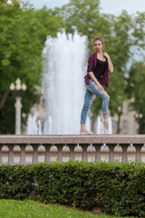 Girl ballerina in jeans, a plaid shirt and pointe shoes dancing in the city on the street © Tatiana