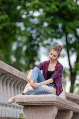 Girl ballerina in jeans, a plaid shirt and pointe shoes dancing in the city on the street © Tatiana
