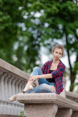 Girl ballerina in jeans, a plaid shirt and pointe shoes dancing in the city on the street © Tatiana