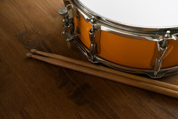 Fototapeta na wymiar Drum and drum stick on wooden table background, top view, music concept