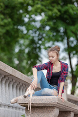 Girl ballerina in jeans, a plaid shirt and pointe shoes dancing in the city on the street © Tatiana