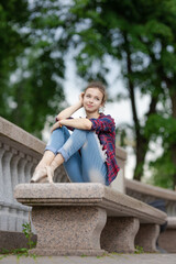 Girl ballerina in jeans, a plaid shirt and pointe shoes dancing in the city on the street © Tatiana