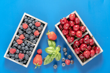 blueberries and cherries in wooden boxes
