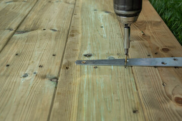Close up of drill being used to fix door hinges 