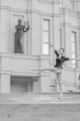 Fototapeta na wymiar Black and white photo, ballerina girl in pointe shoes dancing and posing on the street