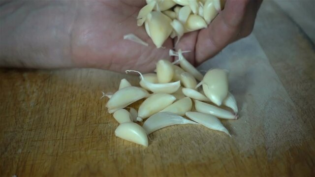 A handful of garlic cloves in hand in slow motion