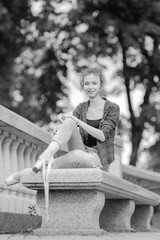 Black and white photo of a ballerina girl in jeans and pointe shoes, dancing and posing in the city on the street © Tatiana