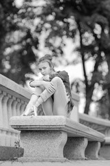 Black and white photo of a ballerina girl in jeans and pointe shoes, dancing and posing in the city on the street © Tatiana