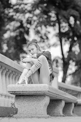 Black and white photo of a ballerina girl in jeans and pointe shoes, dancing and posing in the city on the street © Tatiana