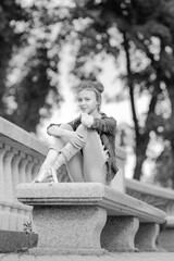 Black and white photo of a ballerina girl in jeans and pointe shoes, dancing and posing in the city on the street © Tatiana