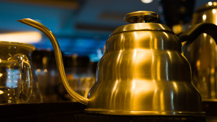 Close up a half side image of stainless steel coffee pot with the blurred background.