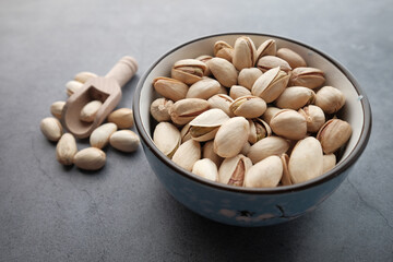 Pistachios nut in a bowl on gray background 
