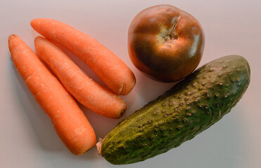 Fresh Whole Kumato Tomato Cucumbers And Carrots Prepared To Make A Salad