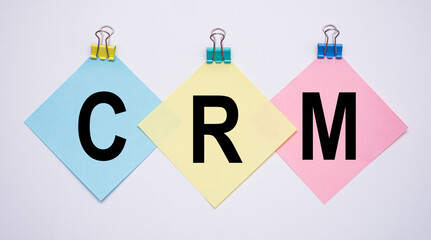 CRM word with paper note on white backgrounds. Business concept.