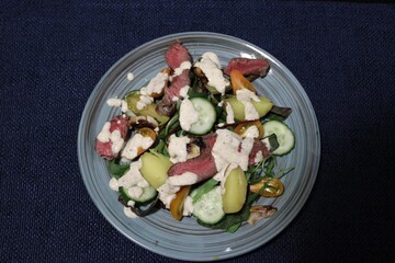 meat salad, which consists of fresh vegetables and medium-rare steak
