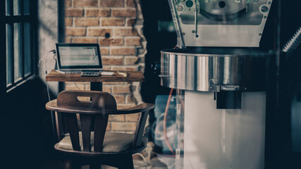 Laptop computer with roasting machine in coffee shop