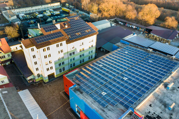 Fototapeta na wymiar Aerial view of many photo voltaic solar panels mounted of industrial building roof.