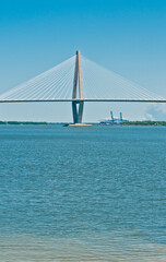 Front view, very far distance of a cable spaced bridge crossing a large, body of water, on a sunny afternoon
