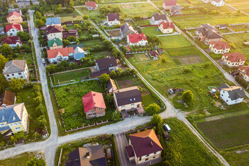 Aerial landscape of small town or village with rows of residential homes and green trees.