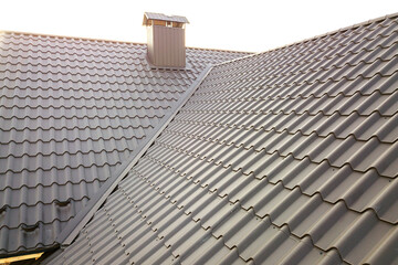 Fototapeta premium Close up of new house roof structure covered with metal tile sheets.