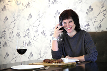 Girl eats steak with wine. Girl passionately eats steak. Steak and wine.