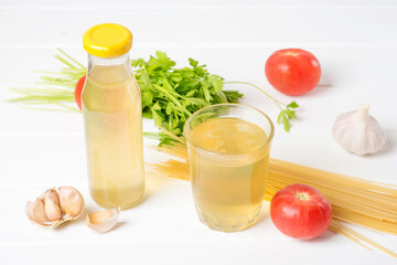 Vegetables, herbs and spices on the table for the vegetable broth. Vegetable broth in a glass. Bio healthy food, organic vegetables Cooking, healthy food or vegetarian concept