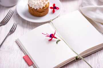 Mockup porcelain plate with cake and opened recice book, notebook, book