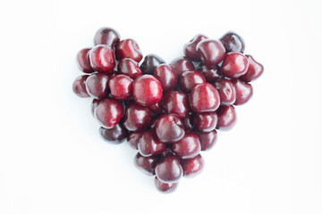 Heart shaped red cherries on a white background. Background from cherries. Sweet cherry isolated on a white background cutout.