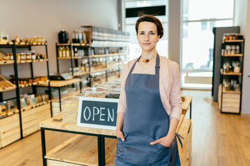 Ended the lockdown and quarantine. Business woman owner holding sign that says now we are open...