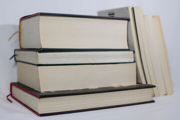 a few thick books stacked together, few thin books are laying to others