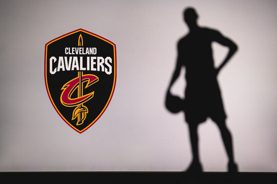 NEW YORK, USA, JUN 18, 2020: Cleveland Cavaliers logo of professional basketball club in american league. Silhouette of basket player in foreground. Sport concept photo, edit space.