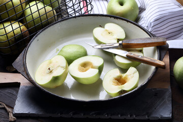 Halves of green apples on a cast-iron pan