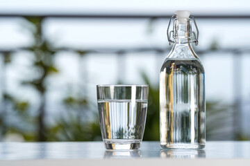Drink water bottle with glass on table at garden home