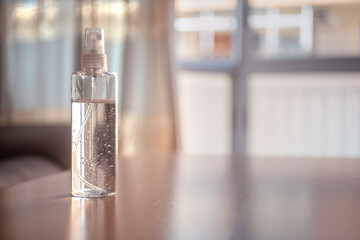 gel desinfectante, con alcohol, en una mesa y muebles de fondo.