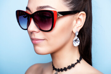 Decoration on the neck. Girl with a choker. Woman in sunglasses. Earrings on the ears.