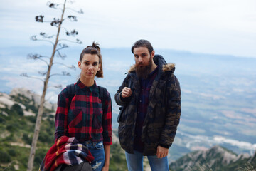 Half length portrait of young hikers resting after long way standing on mountain trail with beautiful view on background