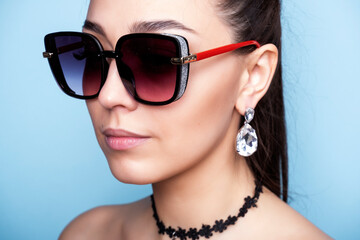 Fototapeta na wymiar Profile of a woman in sunglasses. Fashionable girl with earrings in the ears.