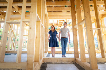 Loving couple at construction site of their new home dreams come true - obrazy, fototapety, plakaty