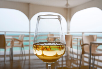 A glass of white wine on the background of a cafe in inclement weather on the beach