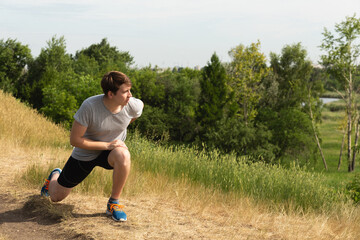 A man flexes before training outdoors. Doing sports in the park and outdoors. Healthy lifestyle concept.