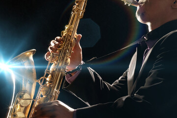 Fototapeta na wymiar Man Playing Saxophone against black background