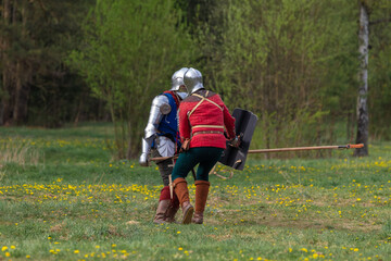Knights in armor fight on the battlefield. Reconstruction of an ancient battle of the 15th century.