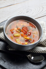 Tomato soup with potatoes, carrots, corn, barley and green onions