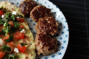 Greek grill meatball on pita with tomato and cucumbers