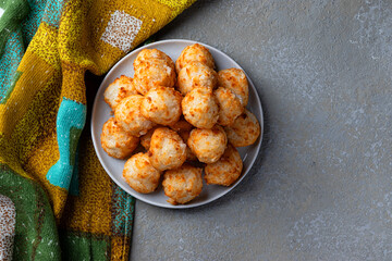 Energy balls with coconut and nuts on a white plate, homemade wholesome food. Diet. View from above