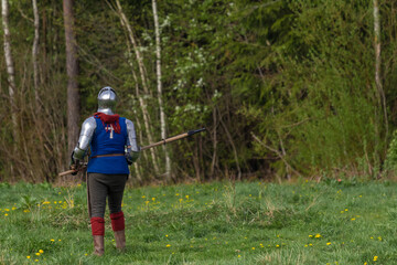 Knights in armor fight on the battlefield. Reconstruction of an ancient tournament of the 15th...