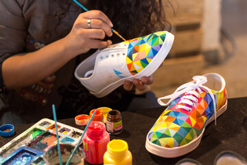A female designer painting a shoe. - Powered by Adobe
