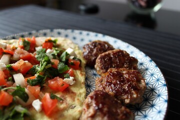 Greek grill meatball on pita with tomato and cucumbers